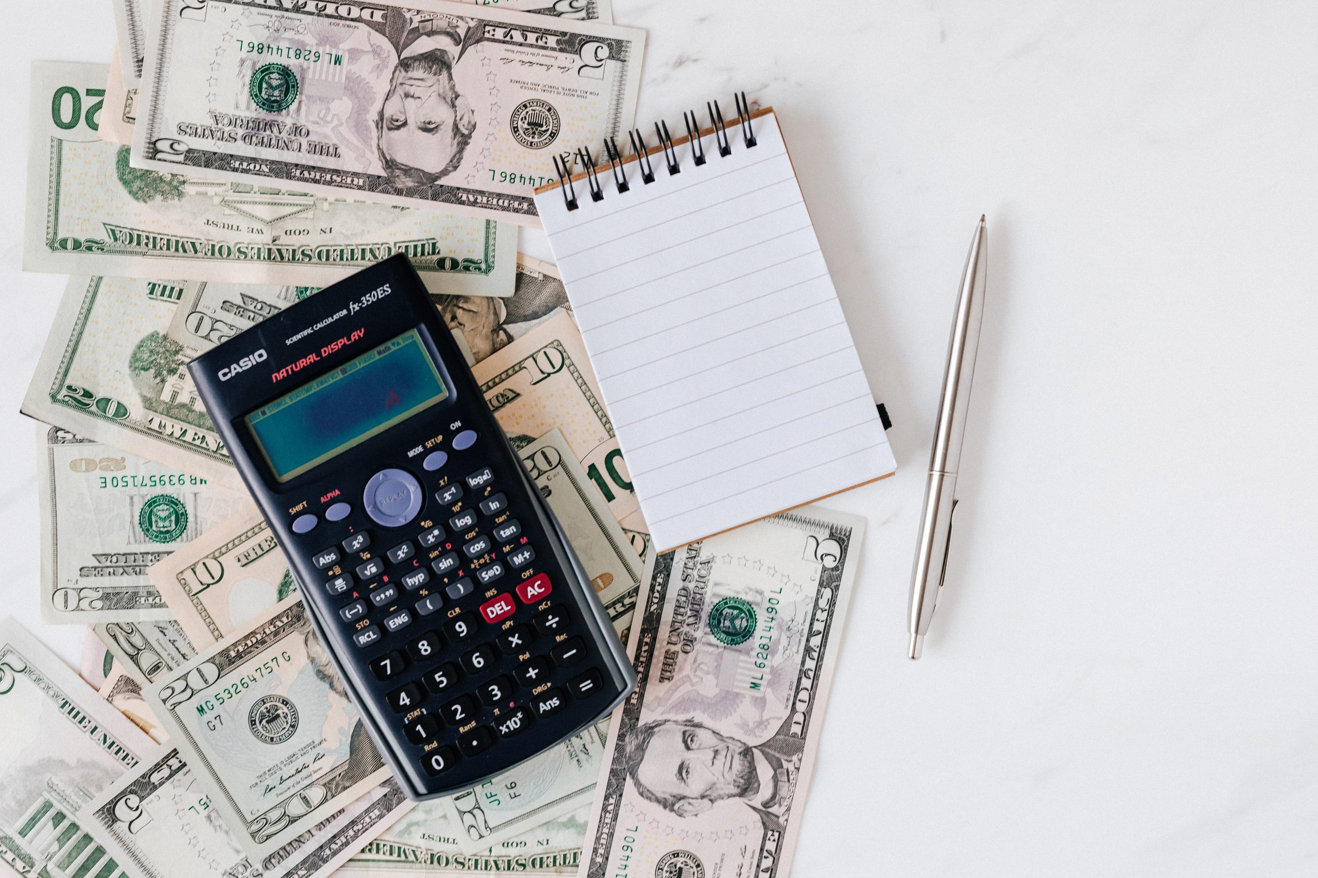 cash, calculator, and notepad